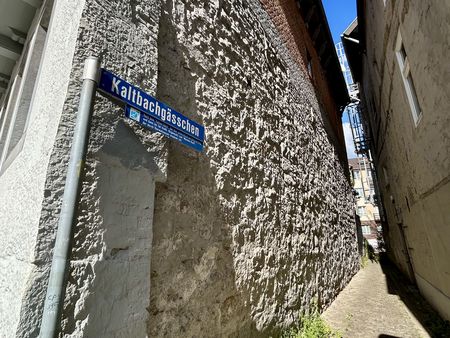 Schmale Gasse zwischen Steinfassaden und einem Straßenschild "Kaltbachstraße".
