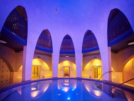 Rundes Becken des Orientalischen Bads in den Carolus Thermen umrandet von hohen Torbögen.