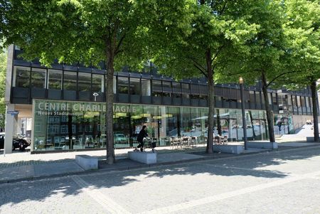 Glasfront des Centre Charlemagne mit grünen Bäumen davor.