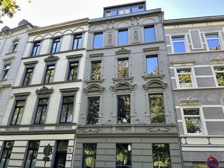 Hellgraue Häuserfassaden von hohen Reihenhäusern.