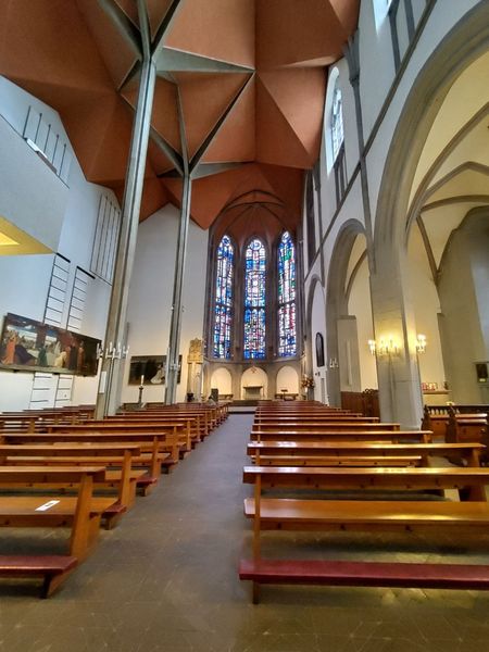 Kirchenraum von Innen mit gemütlicher Beleuchtung und Holzbänken.